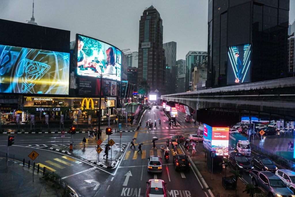 An urban street at night with illuminated billboards and traffic
