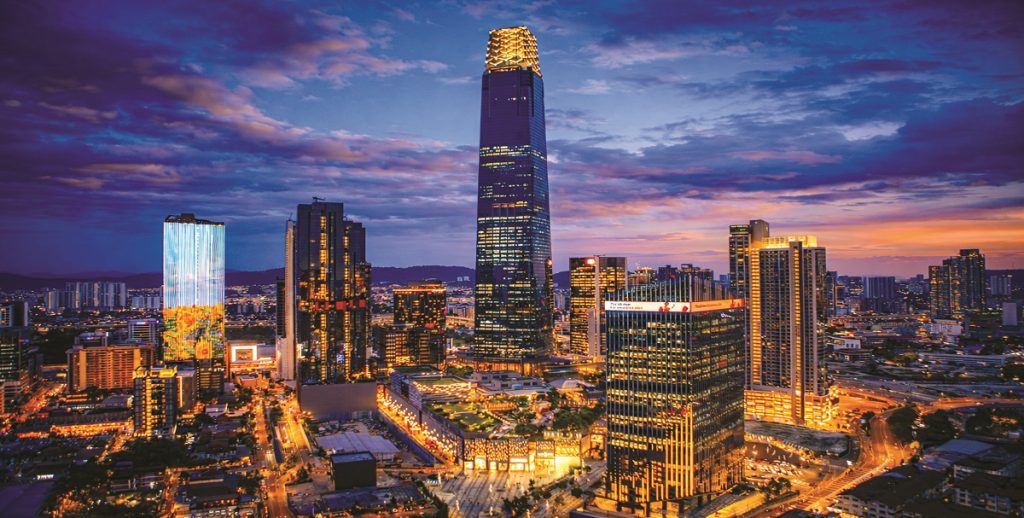 An illuminated high-rise tower against an evening city skyline